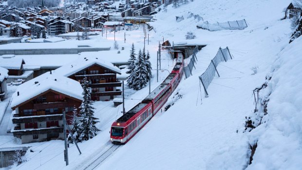 The first passenger train is leaving the train station towards Taesch, in Zermatt, Switzerland.