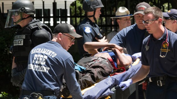 Paramedics rush a stabbing victim away on a gurney, after members of right-wing extremists groups holding a rally outside the California state Capitol building in Sacramento clashed with counter-protesters, authorities said. 
