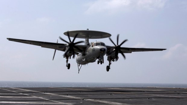 A US Navy E-2 Hawkeye prepares to land on the runway of the US Navy aircraft carrier USS George Washington, during a tour of the ship in the South China Sea.