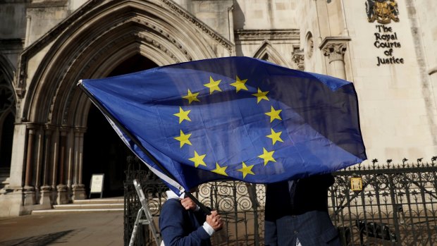 A pro-EU membership supporter holds an EU flag outside the High Court.