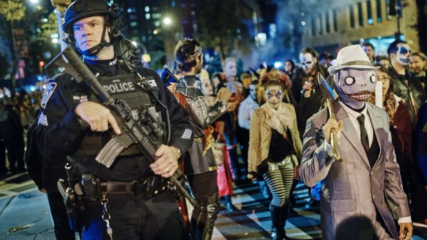 Heavily armed police guard as revelers march during the Greenwich Village Halloween Parade