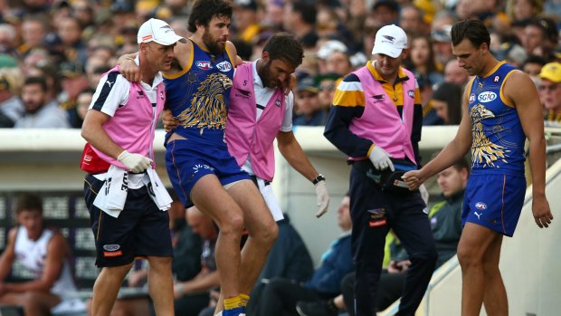 Josh Kennedy is assisted from the field with a lower leg injury during the round 10 AFL match between the West Coast Eagles and the Giants.