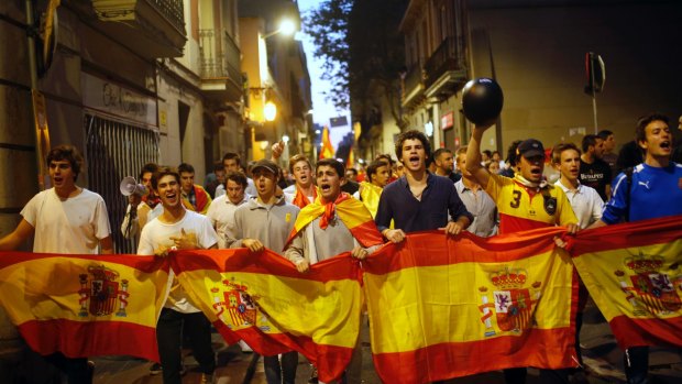 Anti Catalan independence demonstrators carry a Spanish flag as they march in Barcelona, Spain.
