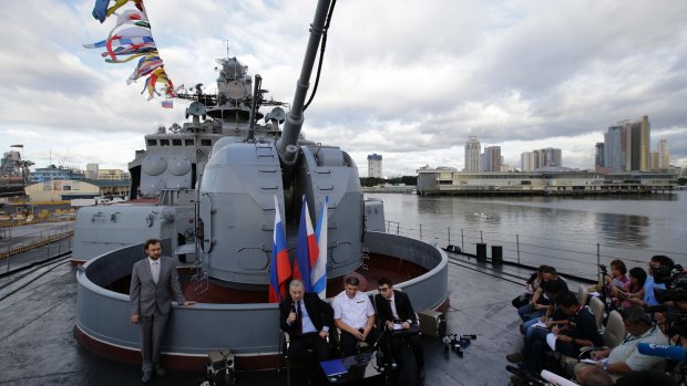 Russia's Ambassador to the Philippines answers questions from reporters beside Russian Admiral during a press conference on board the Russian Navy vessel Admiral Tributs in Manila.