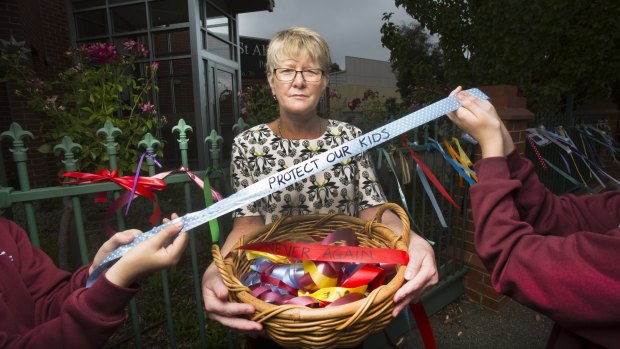 Principal Eileen Rice with colourful ribbons students have attached to the fences at St Alipius Parish School. 