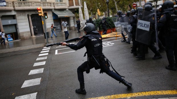 Spanish police in Barcelona shoot rubber bullets at people visiting a Catalan polling station.