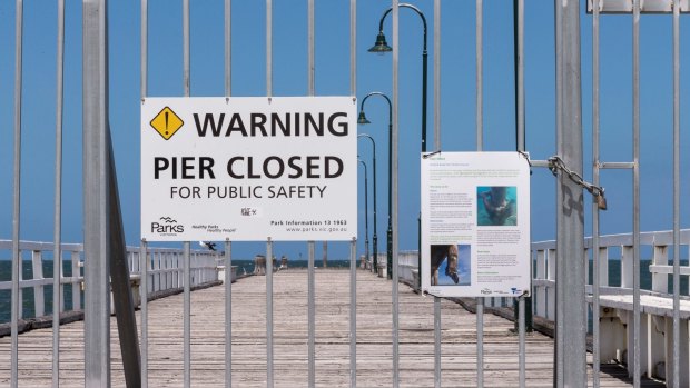 Warning signs on Kerferd Road pier where it is partially closed.