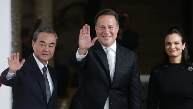Chinese Foreign Minister Wang Yi, left, waves with Panamanian President Juan Carlos Varela and Foreign Minister Isabel de Saint Malo, in Panama City, on Saturday,