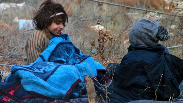 Evacuated children sitting on the ground in western rural Aleppo.