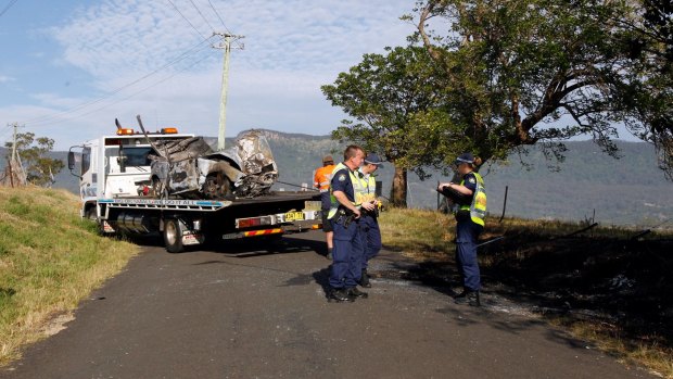 The mangled wreckage of the car is taken away after the fatal crash in Dapto.