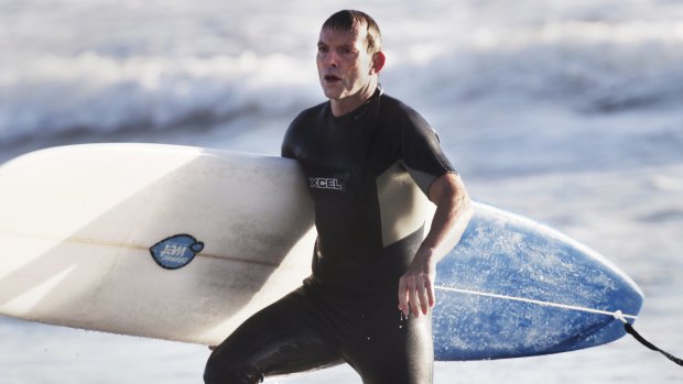 Tony Abbott, pictured surfing in 2014, went to hospital for a "couple of stitches" after encountering rough surf conditions on Friday morning.