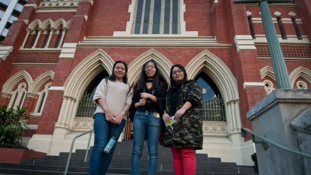 Chinese tourists Xinjie Lu, Ke Wany and Shunran Li are among the thousands of international tourists stopping now visiting the Albert Street Uniting Church.