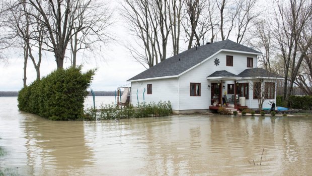 A home is surrounded by floodwater, Tuesday, May 2, 2017 in Rigaud, Quebec. Numerous Quebec municipalities that border streams and rivers are dealing with floods as heavy rain and mild temperatures have caused water levels to rise rapidly. (Paul Chiasson/The Canadian Press via AP)