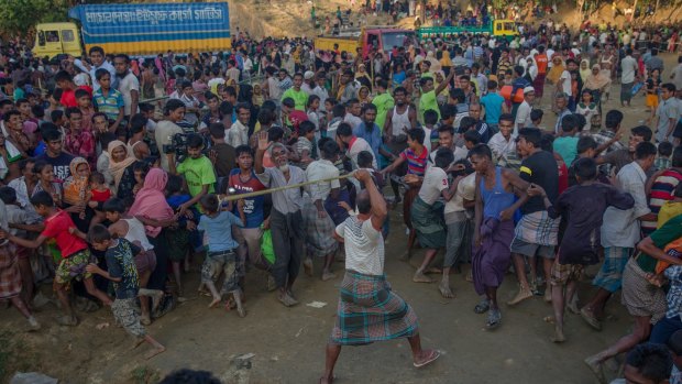 A Rohingya Muslim, who crossed over from Myanmar into Bangladesh, beats other refugees as a fight broke out during a distribution of aid near Balukhali refugee camp.