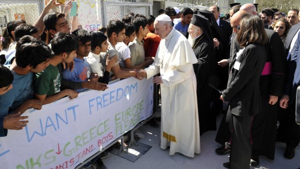 Pope Francis and Ecumenical Patriarch Bartholomew I greet migrants and refugees during a visit to the Moria camp.