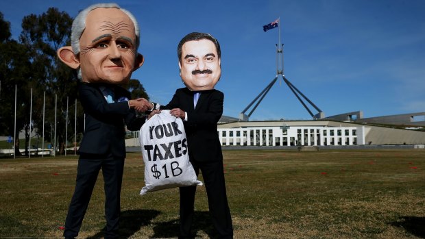 Protestors wearing suits resembling Prime Minister Malcolm Turnbull and Adani chief Gautam Adani take part in a protest in Canberra on Thursday.