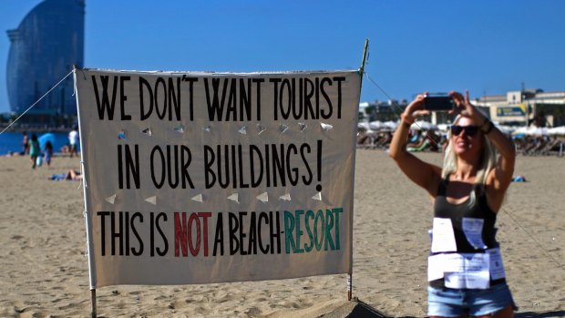 A woman takes a picture during a protest against tourism in Barcelona.