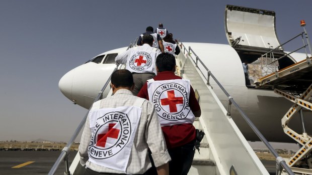 Red Cross staffers board a plane carrying a shipment of emergency medical aid at Sanaa airport in Yemen on Saturday.