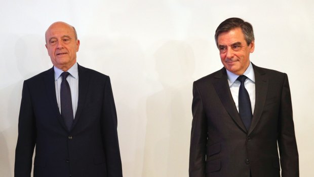 The conservative party's presidential nominee, Francois Fillon, right, and runner-up, Alain Juppe, pose for photographers.