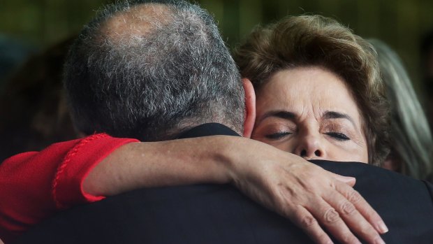 Dilma Rousseff (R) hugs a supporter after delivering her farewell speech.