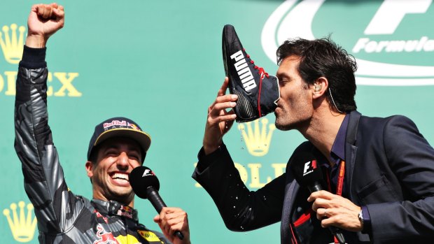 SPA, BELGIUM - AUGUST 28: Mark Webber drinks champagne from the boot of Daniel Ricciardo of Australia and Red Bull Racing on the podium during the Formula One Grand Prix of Belgium at Circuit de Spa-Francorchamps on August 28, 2016 in Spa, Belgium (Photo by Mark Thompson/Getty Images)