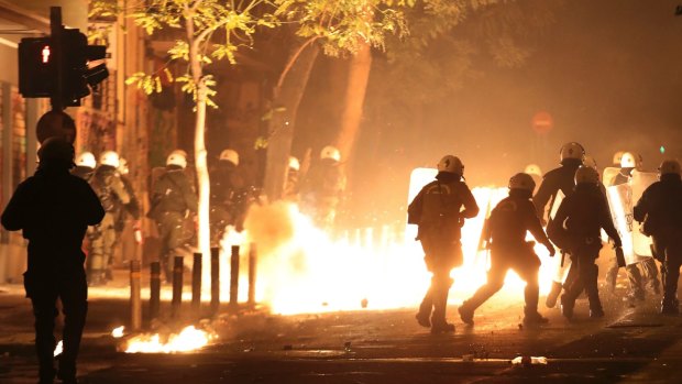 Riot police try to avoid petrol bombs and flares thrown by protesters during clashes in Athens.