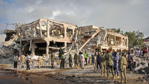 Somali security forces gather near destroyed buildings at the scene of  the Mogadishu blasts.