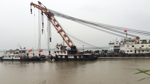 Workers prepare a crane to lift upright the capsized cruise ship in the Yangtze River in Jianli county in southern China's Hubei province, on Thursday.