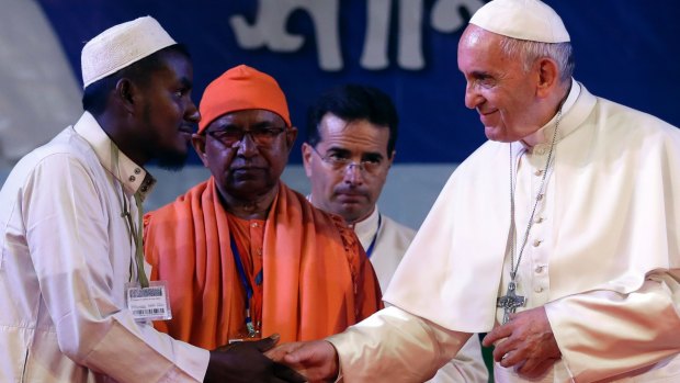 Pope Francis, right, shakes hands with a Rohingya Muslim refugee during an interfaith and ecumenical meeting for peace in the garden of the archbishop's residence, in Dhaka, Bangladesh.