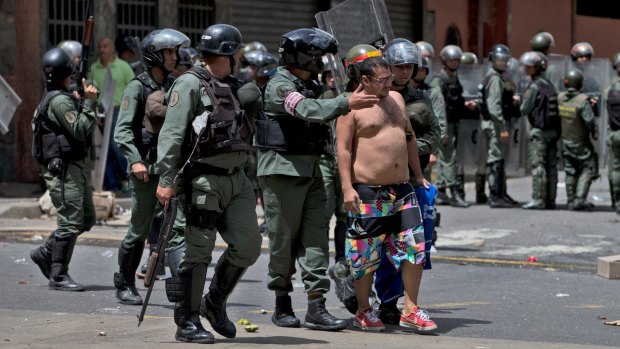 Bolivarian National Guards detain a man a few blocks from Miraflores presidential palace in Caracas.