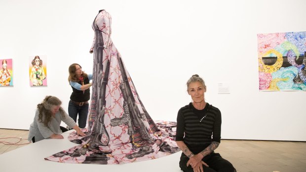 Artist eX de Medici (right) in front of her work 'Shotgun wedding dress' which is now on display at the National Gallery of Australia.
