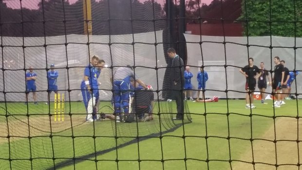 Australia players and staff surround an Adelaide club cricketer after he was struck on the head by a ball hit by all-rounder Mitch Marsh during a training session under floodlights at Adelaide Oval, in preparation for the pink-ball Test. 