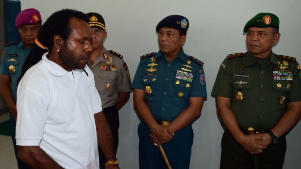 Indonesian police and military officials look on as freed Papuan political prisoner Jefrai Murib arrives for the ceremony.
