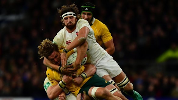 Michael Hooper of Australia (L) is tackled by Tom Wood of England (R) during the Old Mutual Wealth Series match between England and Australia at Twickenham.