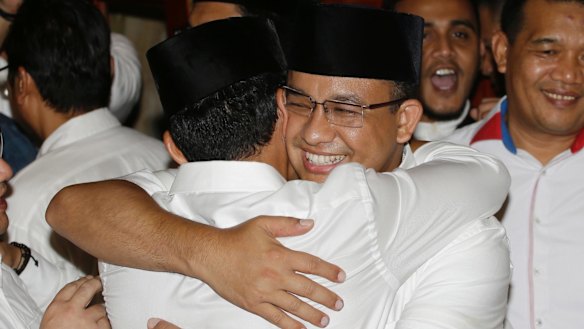 Jakarta's governor-elect Anies Baswedan, right, hugs his running mate  as unofficial results showed him defeating Ahok on April 19.