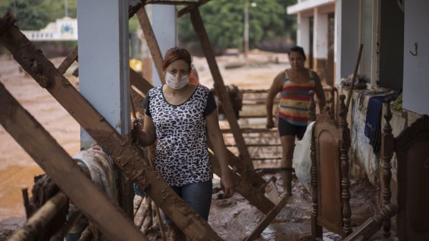 People stand in their damaged home in Barra Longa after a dam burst in Minas Gerais state, Brazil.