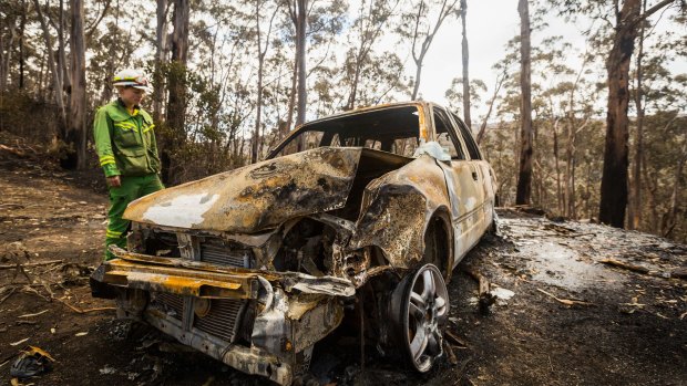 Firefighter Anna Cutriss inspects a burnt out car in Wye River on December 27.