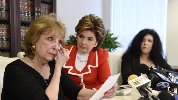 Sunni Welles, left, outlines her case of rape against Bill Cosby at a news conference with attorney Gloria Allred (in red) as another alleged victim, Margie Shapiro, looks on in Los Angeles on Friday. 