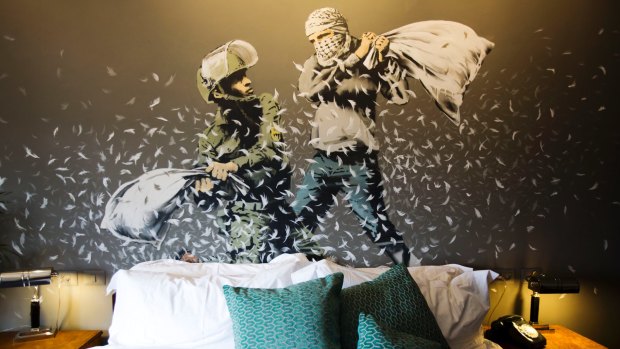 Banksy's wall painting showing an Israeli border policeman and a Palestinian in a pillow fight in one of the suites of the Walled Off Hotel.