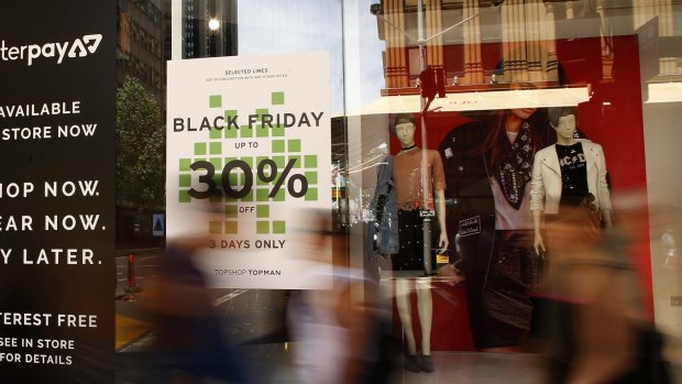 Pedestrians walk past a Black Friday sale advertisement in Sydney. 