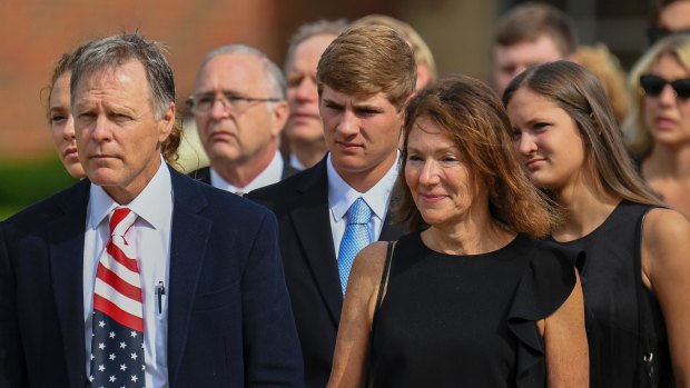 Fred and Cindy Warmbier, front row, watch as the casket for their son Otto is placed in a hearse after his funeral in Wyoming, Ohio in June.