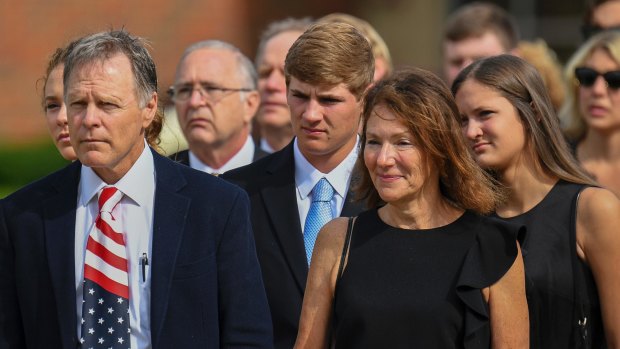 Fred and Cindy Warmbier, front row, watch as the casket for their son Otto is placed in a hearse after his funeral in Wyoming, Ohio in June.