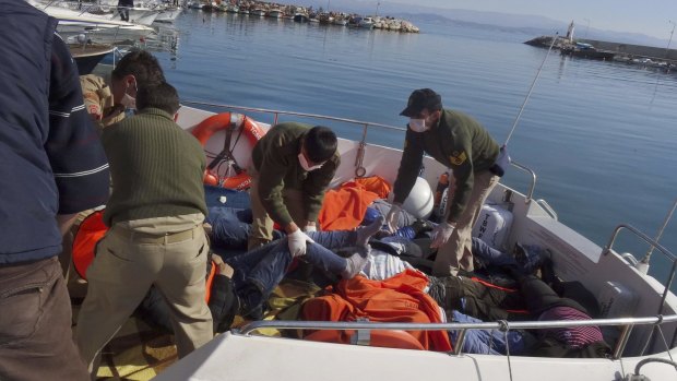 Rescue workers with the bodies of migrants who drowned off the coast of Turkey on Monday.
