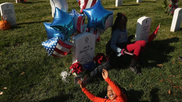 Families unite: Jayla Robinson plays at the grave of her uncle, Sergeant Jack Bryant, who died in Iraq in 2004.