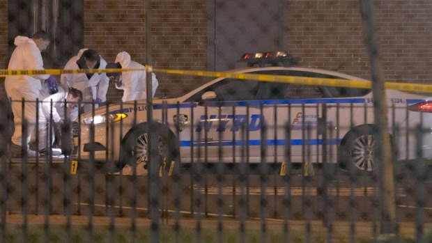 Two dead: Investigators examine the patrol car.