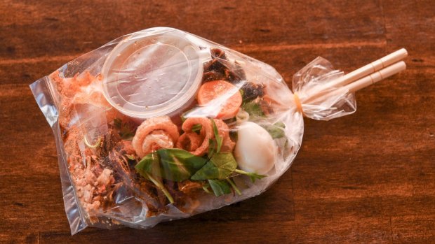 The rice paper salad is delivered in a plastic bag with a set of chopsticks.