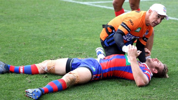 Down: Brendan Elliot is treated after being felled during Newcastle's clash with South Sydney on Saturday. 