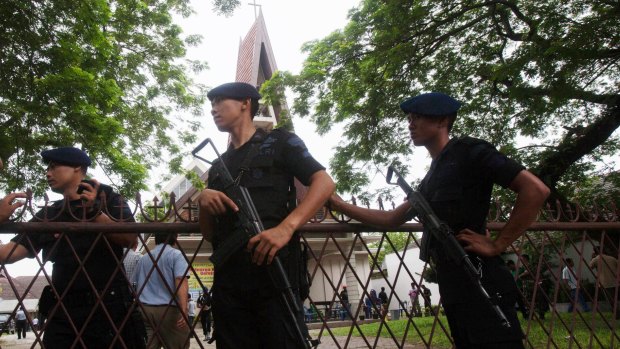 Indonesian police officers guard a church compound following an attack during Sunday mass in Medan, North Sumatra, Indonesia.