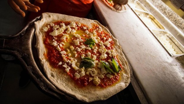 A Neapolitan 'pizzaiuoli' (pizza makers) prepares a pizza, in Naples, Italy,