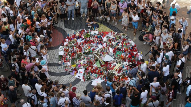 People gather at a memorial on the Joan Miro mosaic on Las Ramblas.